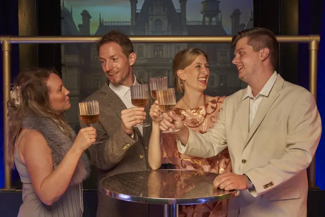 Vier Gäste stoßen auf Gatsbys Party mit Champagner an